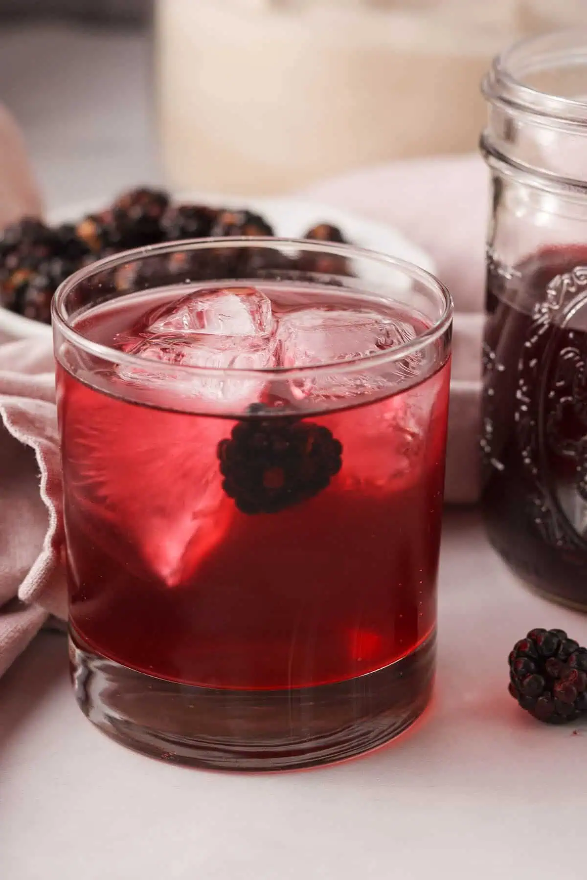 blackberry soda in glass with ice and blackberries