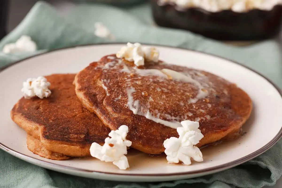 angled closeup of popcorn pancakes on plate with popcorn accenting the plate