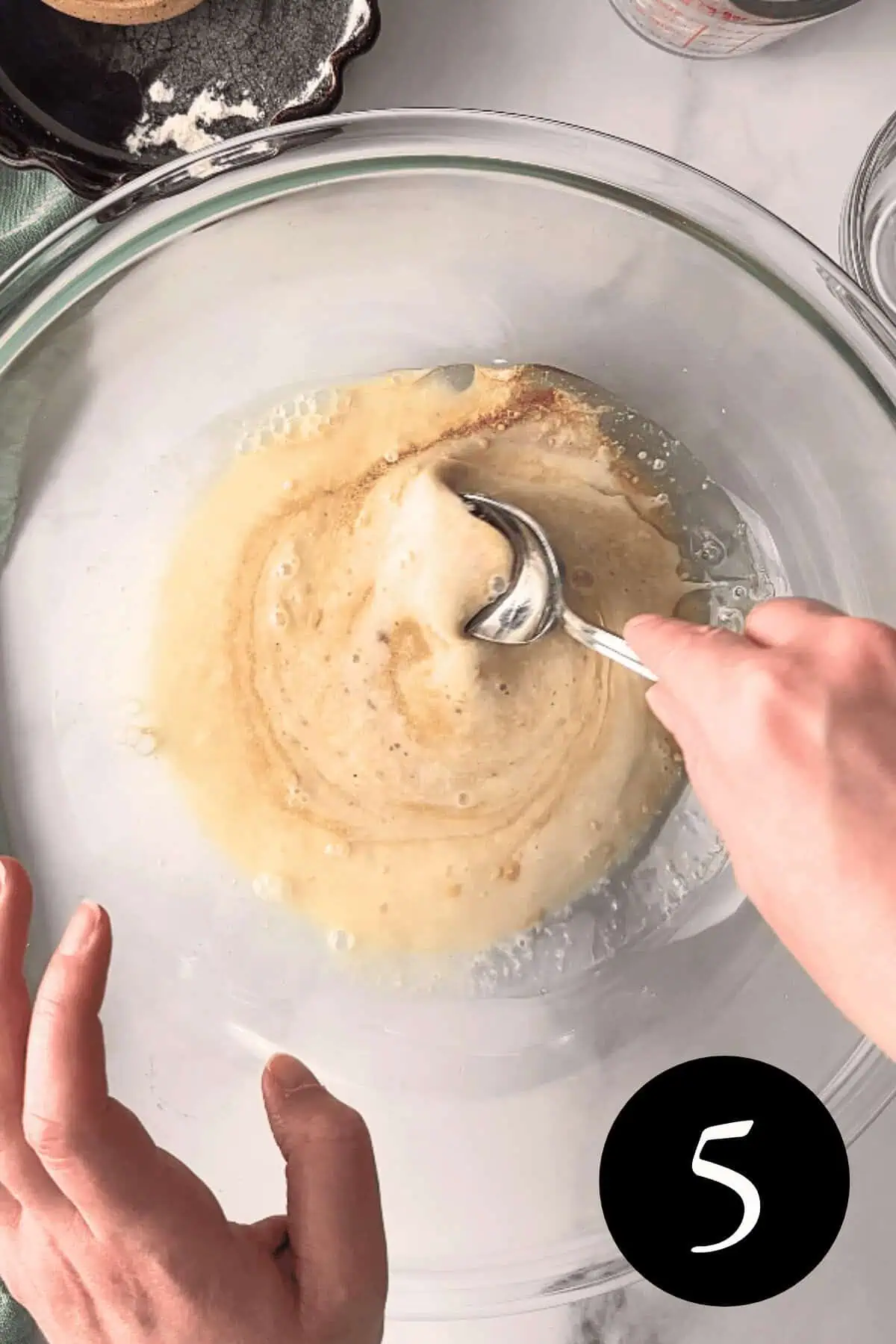 overhead image of mixing wet ingredients in glass bowl with number five in bottom right corner