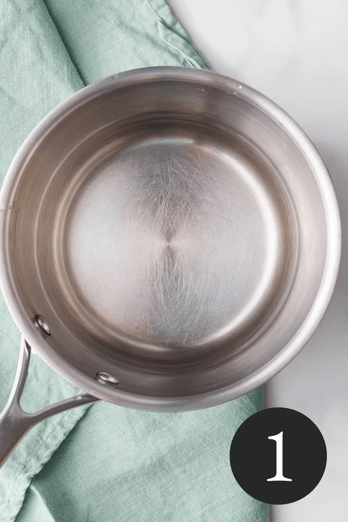 overhead image of water in saucepan with number one in bottom right corner