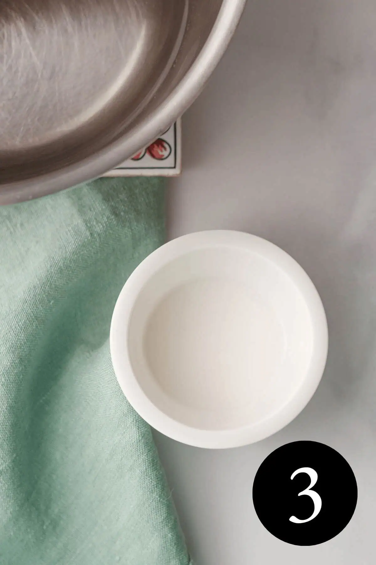 overhead image of arrowroot powder slurry in small white bowl with number three in the bottom right corner