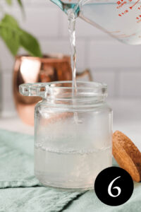 closeup of sugar free simple syrup pouring into glass jar with number six in bottom right corner