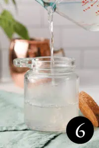 closeup of sugar free simple syrup pouring into glass jar with number six in bottom right corner