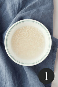 overhead image of rice soaking in bowl with number one in bottom right corner