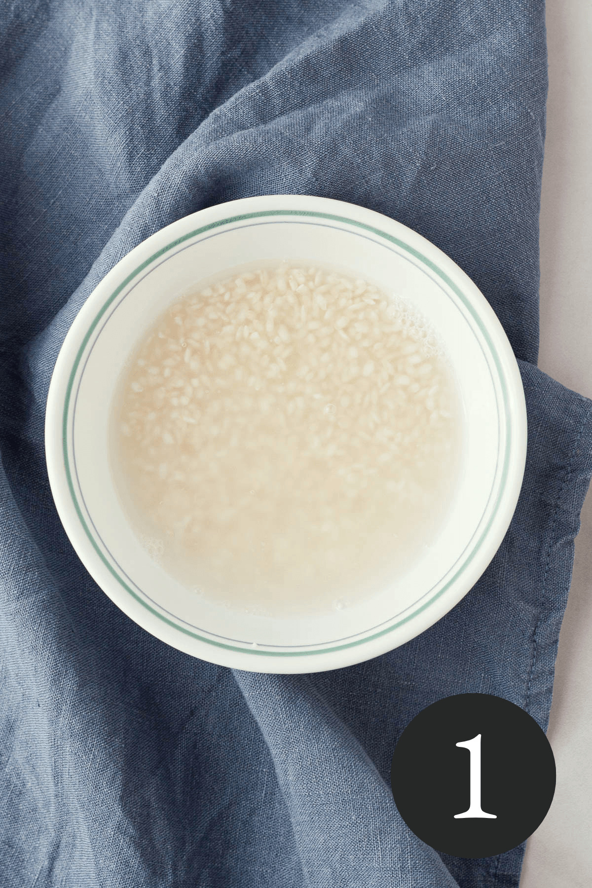 overhead image of rice soaking in bowl with number one in bottom right corner