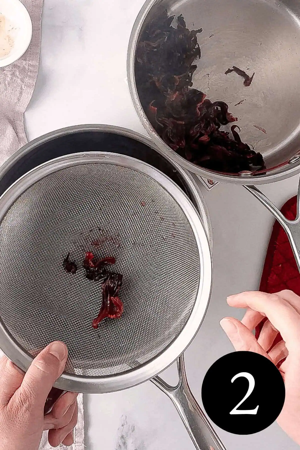 overhead image of two saucepans next to each other with fine mesh sieve over one and number two in bottom right corner