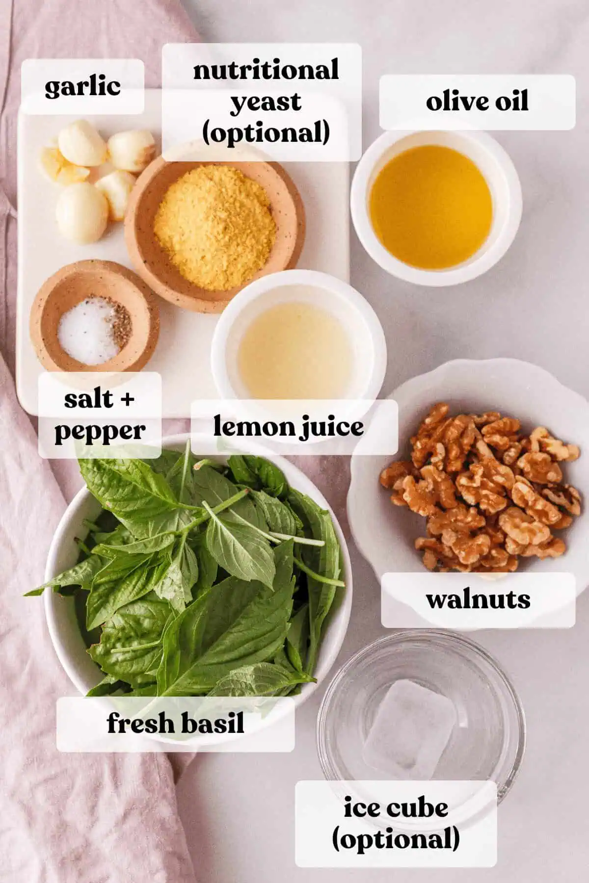 overhead image of vegan basil pesto ingredients on counter with text labels