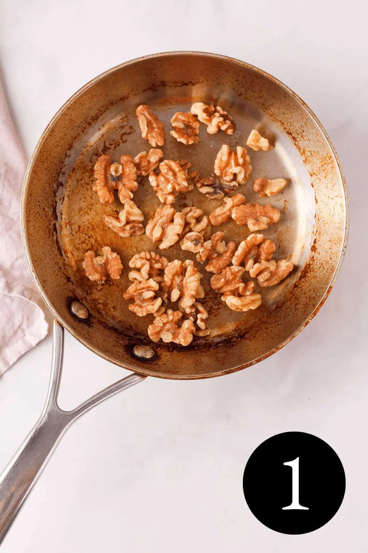overhead image of walnuts in skillet with number one in the bottom right corner
