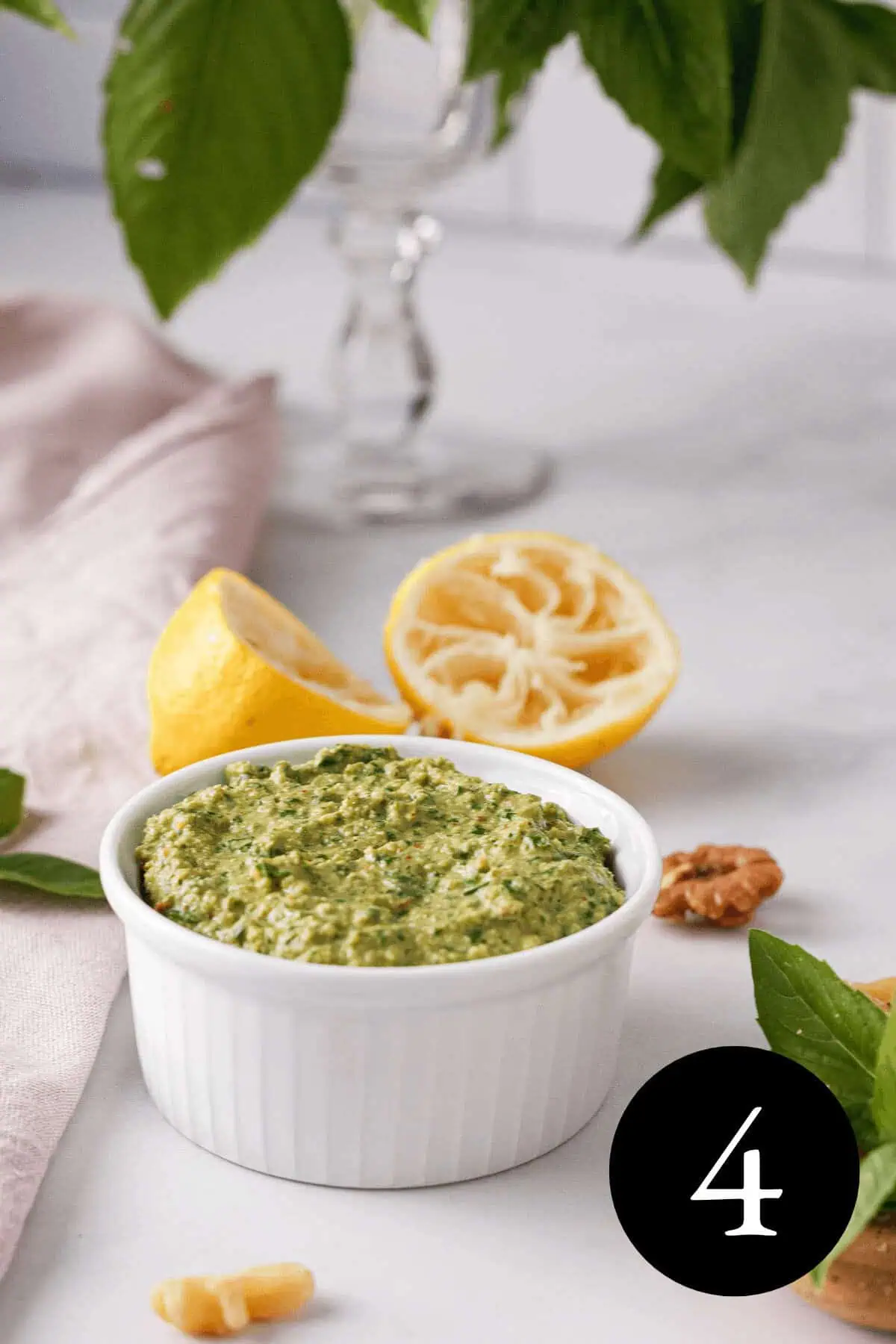 angled image of vegan basil pesto in white jar with number four in the bottom right corner