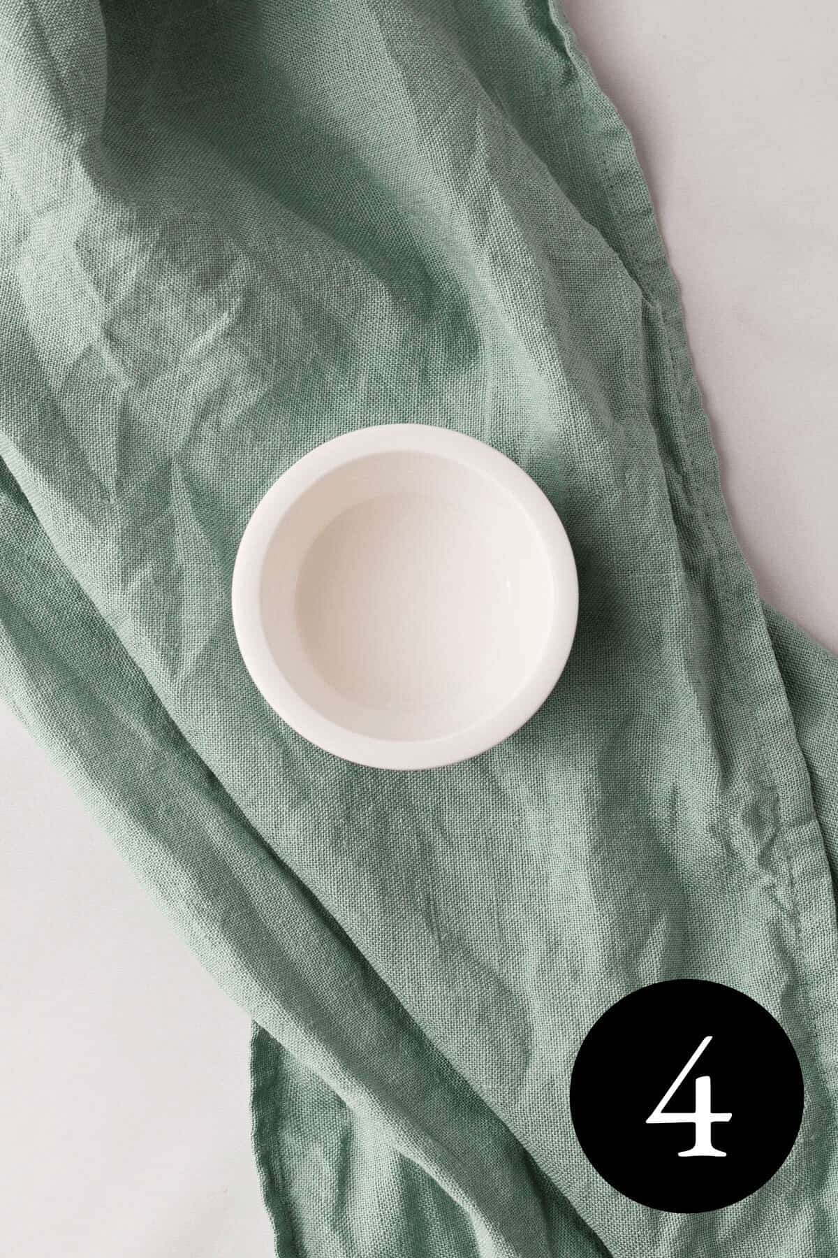 overhead image of arrowroot powder slurry in small white bowl and number four in the bottom right corner