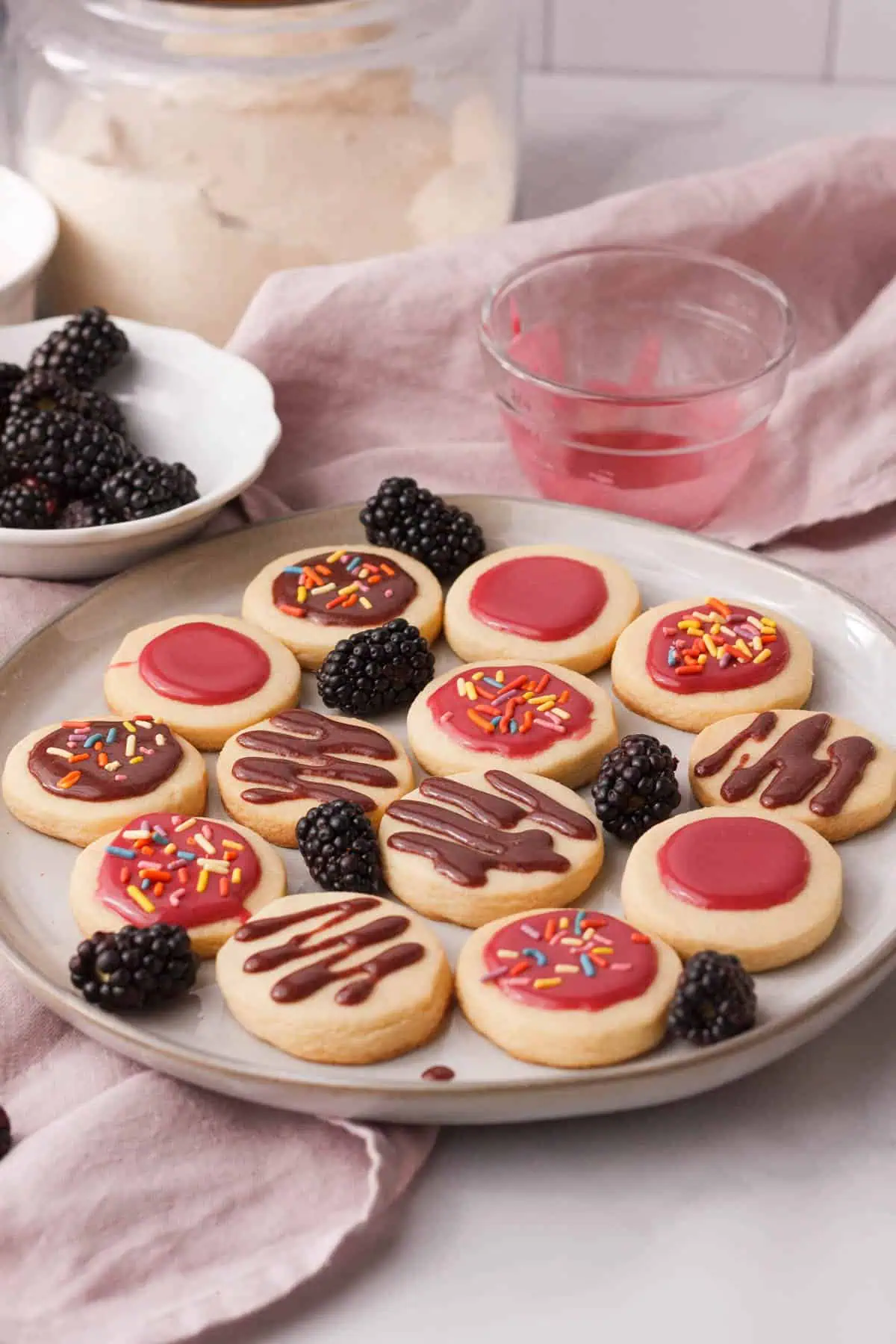 blackberry icing glaze on shortbread cookies with ingredients in background