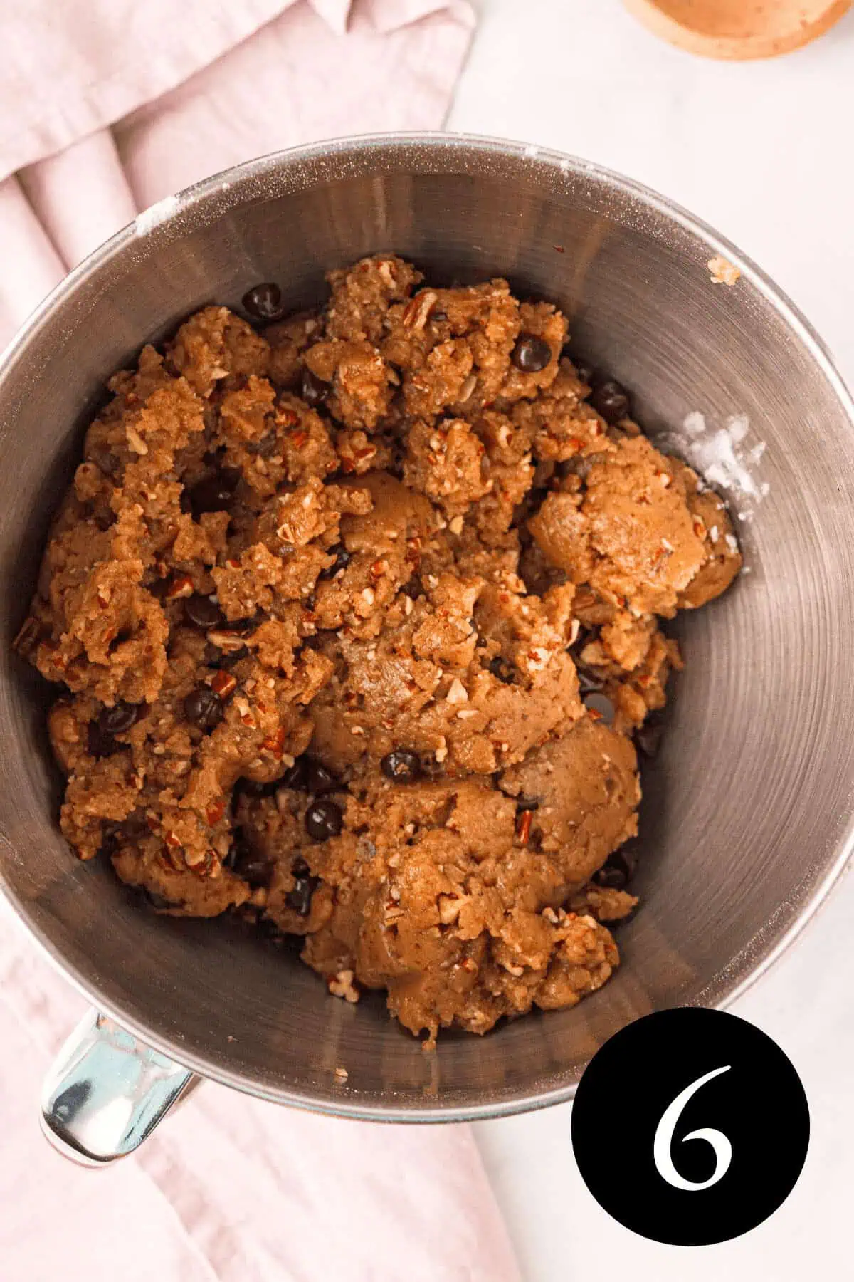 overhead image of cookie dough with pecans and chocolate chips and number six in bottom right corner