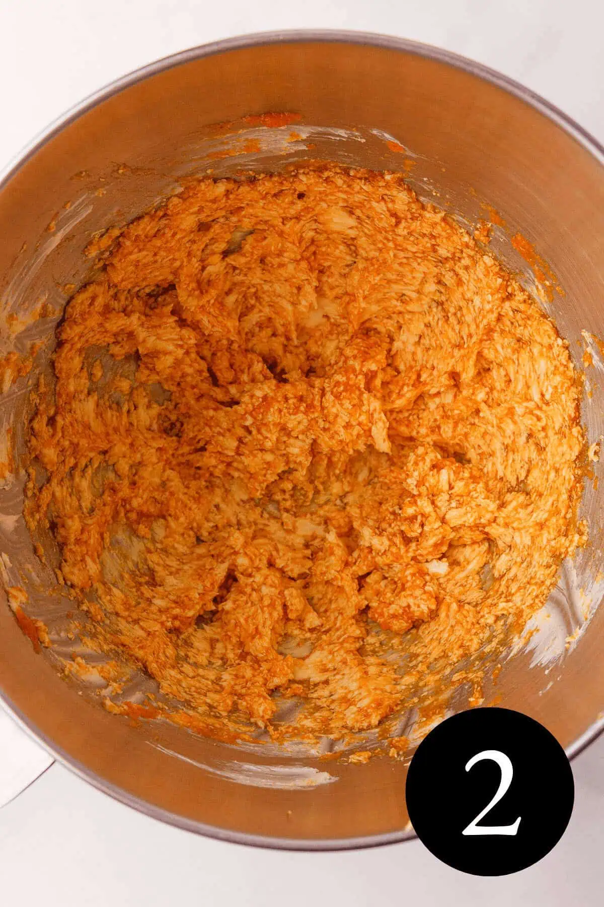 overhead image of wet ingredients creamed together in mixing bowl and number two in the bottom right corner
