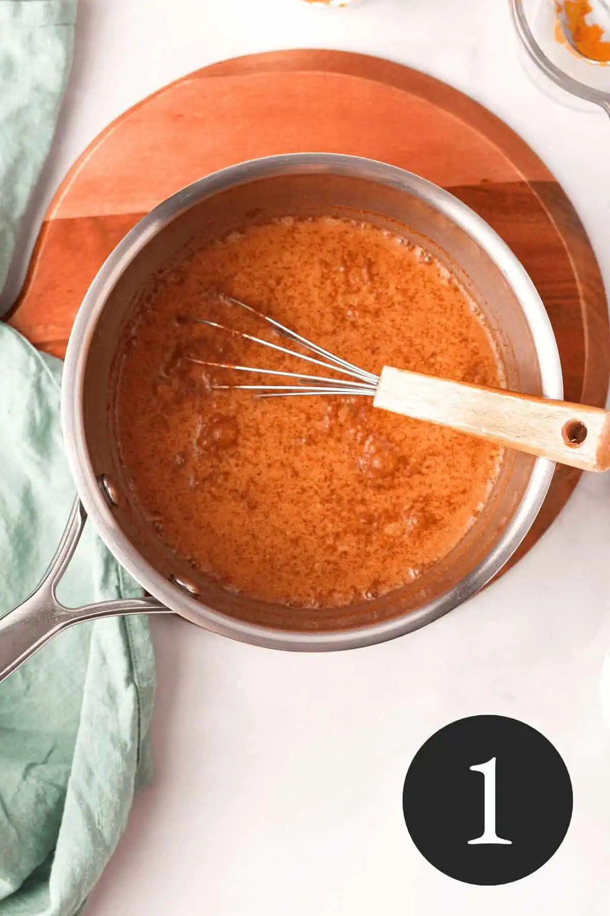 overhead image of whisk and ingredients in saucepan before adding oats and number one in bottom right corner